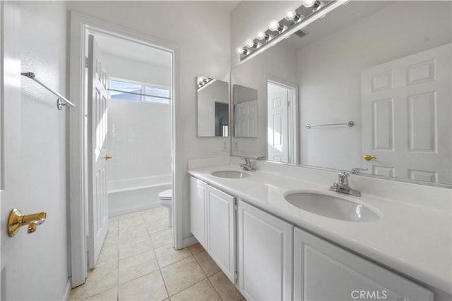 full bathroom with vanity, tile patterned floors, toilet, and washtub / shower combination