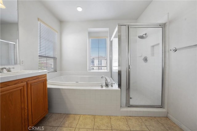 bathroom featuring vanity, a wealth of natural light, tile patterned floors, and shower with separate bathtub