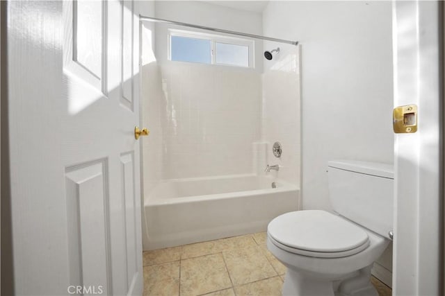 bathroom with tile patterned flooring, tiled shower / bath, and toilet