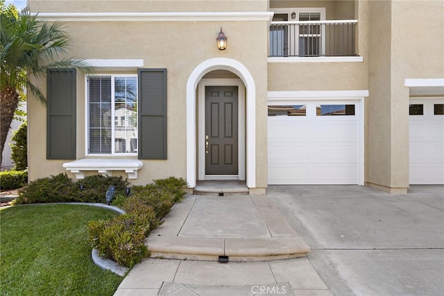 entrance to property featuring a garage and a balcony