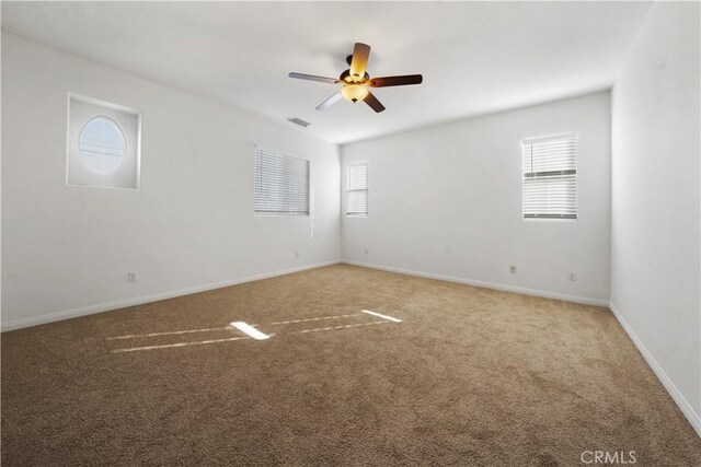 spare room with ceiling fan and carpet