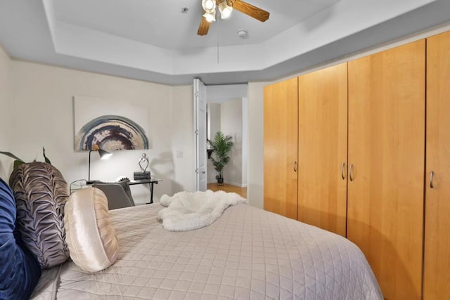 bedroom with a raised ceiling and ceiling fan