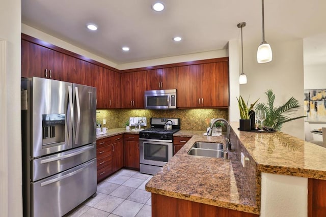 kitchen featuring sink, light tile patterned floors, kitchen peninsula, pendant lighting, and stainless steel appliances