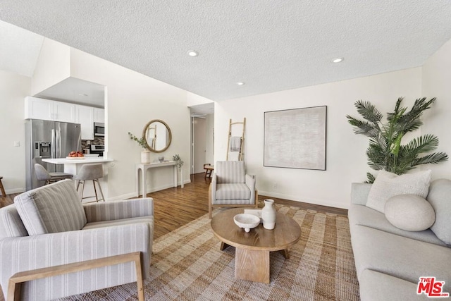 living room with a textured ceiling and light wood-type flooring