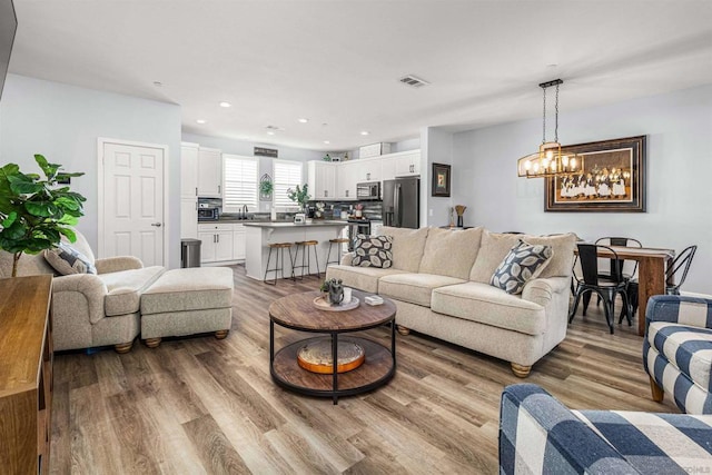 living room featuring light hardwood / wood-style flooring and a chandelier