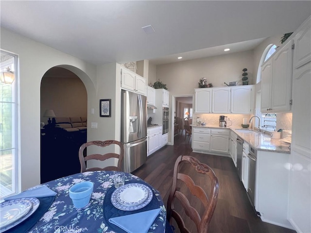 kitchen with tasteful backsplash, sink, stainless steel appliances, and white cabinetry