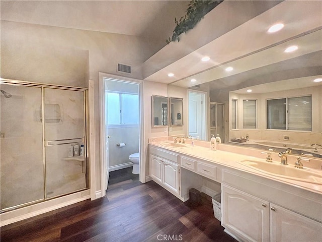 bathroom with toilet, vanity, vaulted ceiling, hardwood / wood-style floors, and an enclosed shower