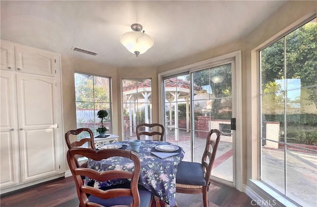 dining space featuring a wealth of natural light and dark hardwood / wood-style flooring