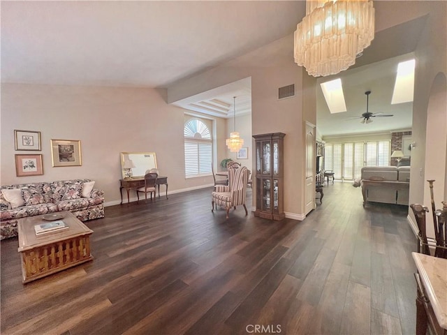 interior space featuring dark hardwood / wood-style flooring, ceiling fan with notable chandelier, and a raised ceiling