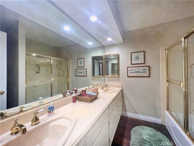 bathroom with enclosed tub / shower combo, hardwood / wood-style flooring, and vanity