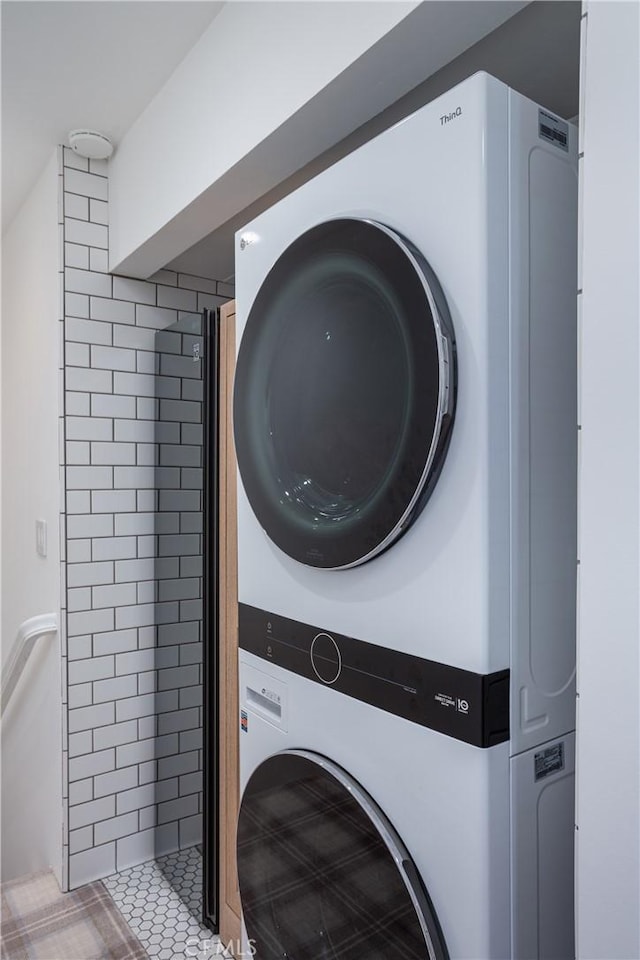 laundry room with stacked washing maching and dryer