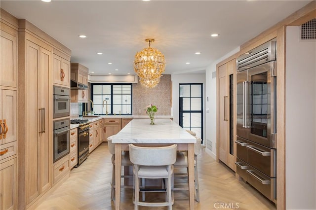 kitchen with light brown cabinets, a chandelier, light parquet flooring, and hanging light fixtures