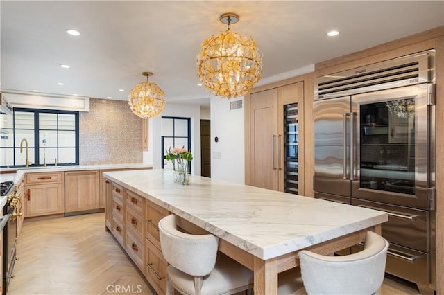 kitchen featuring an inviting chandelier, appliances with stainless steel finishes, backsplash, decorative light fixtures, and light parquet flooring