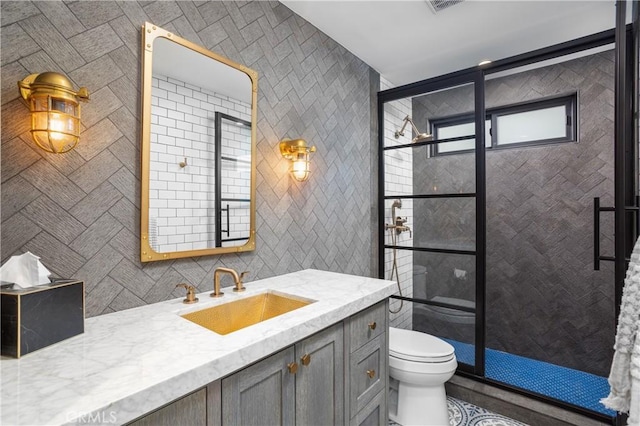 bathroom with tile patterned floors, toilet, vanity, and tile walls