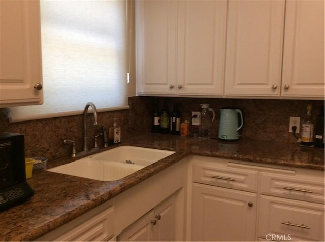 kitchen with sink, backsplash, and white cabinets