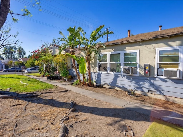 view of front of home with cooling unit and a front yard