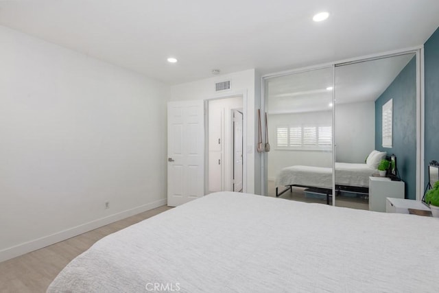 bedroom with a closet and light hardwood / wood-style floors