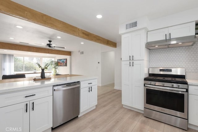 kitchen featuring light hardwood / wood-style floors, decorative backsplash, stainless steel appliances, and white cabinetry