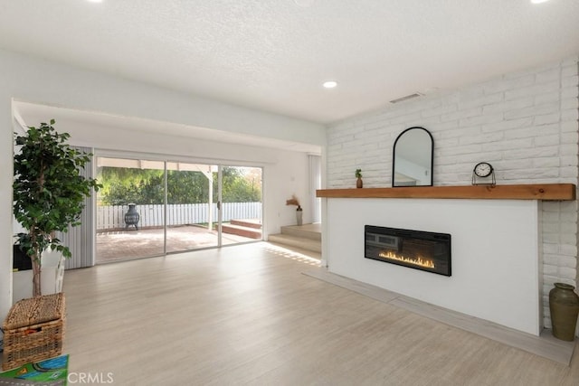 unfurnished living room featuring a fireplace and light hardwood / wood-style flooring