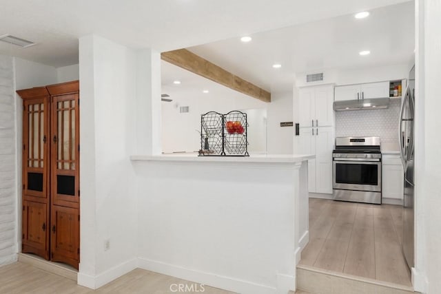 kitchen featuring range hood, stainless steel range oven, backsplash, and white cabinets