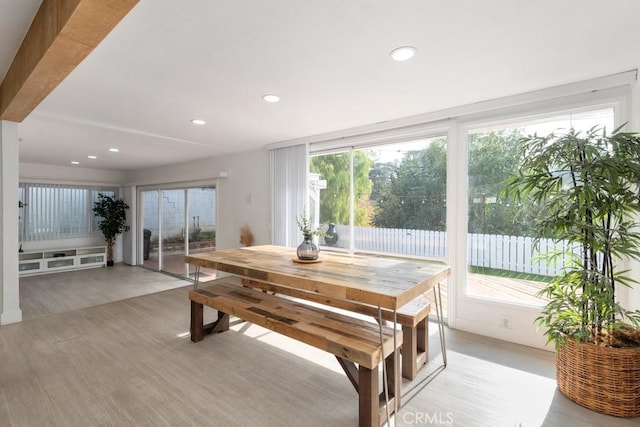 dining area featuring beam ceiling and light hardwood / wood-style flooring