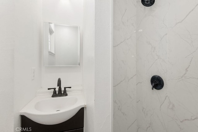 bathroom featuring vanity and tiled shower