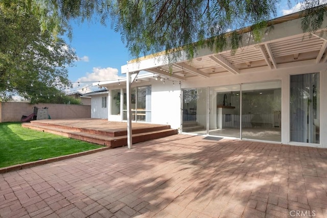 back of house with a wooden deck, a patio area, and a yard