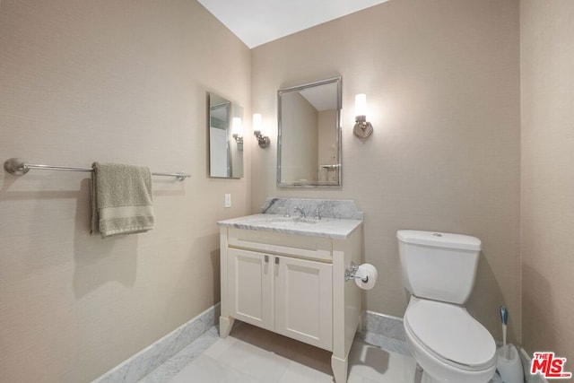 bathroom featuring toilet, vanity, and tile patterned flooring