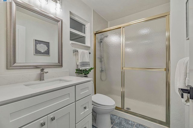 bathroom with vanity, toilet, and a shower with shower door