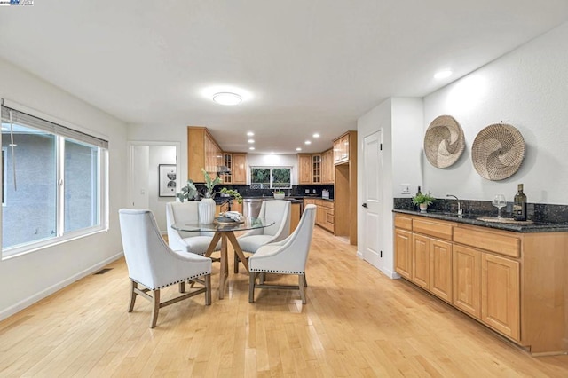 dining space with sink and light hardwood / wood-style floors