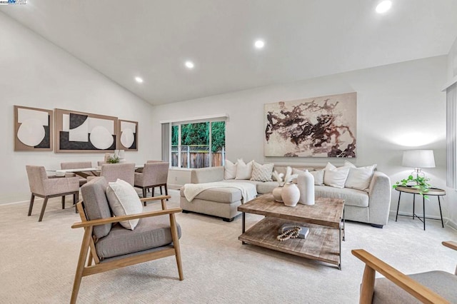 living room with high vaulted ceiling and light colored carpet