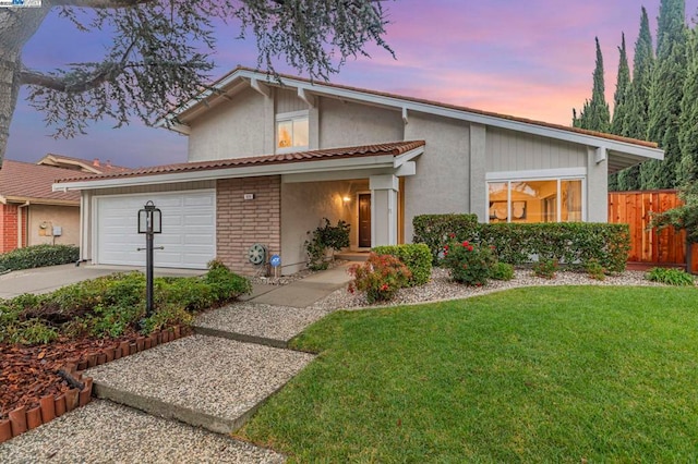 front of property with a garage and a yard