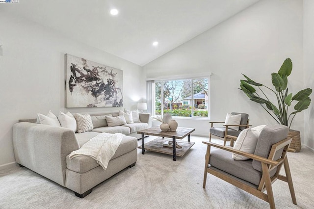 carpeted living room with high vaulted ceiling