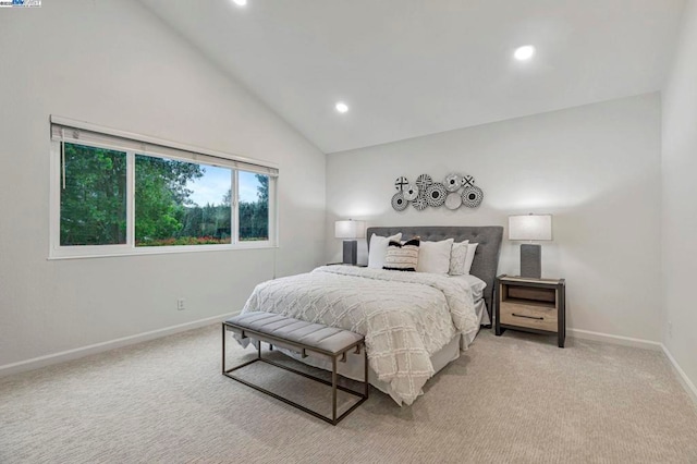 bedroom with light colored carpet and high vaulted ceiling