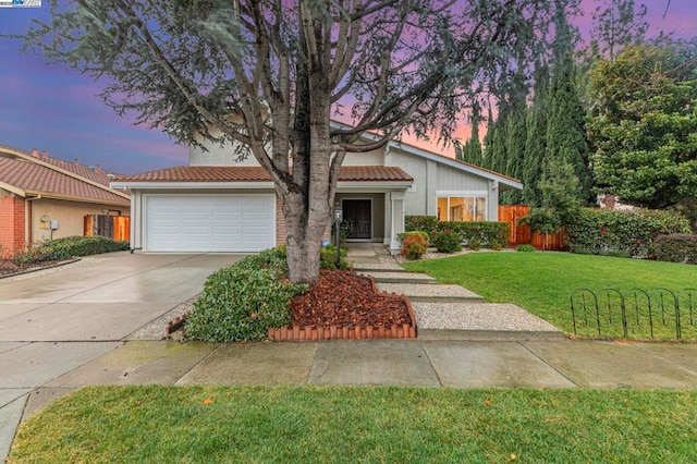 view of front of house featuring a garage and a lawn