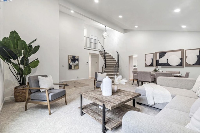 carpeted living room with high vaulted ceiling