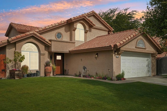 mediterranean / spanish-style house with a yard and a garage