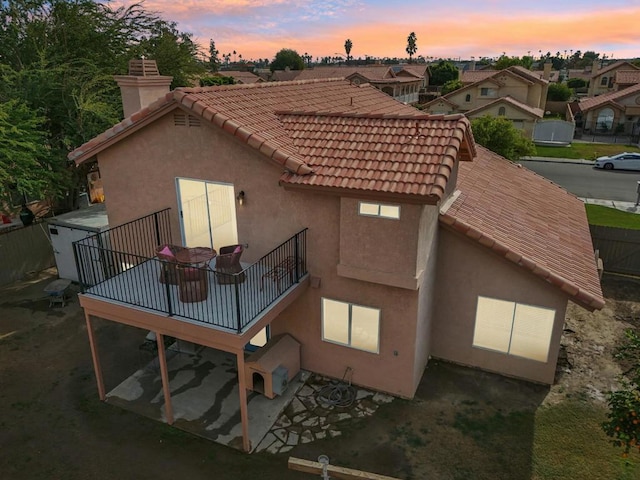 back house at dusk with a balcony