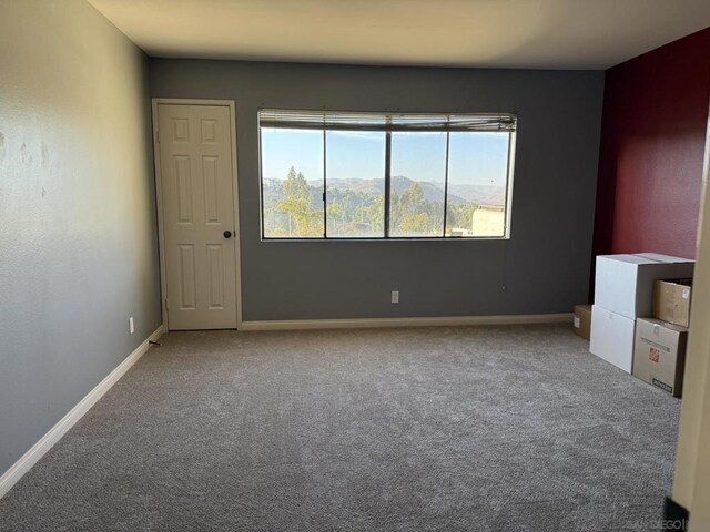 carpeted spare room featuring a mountain view