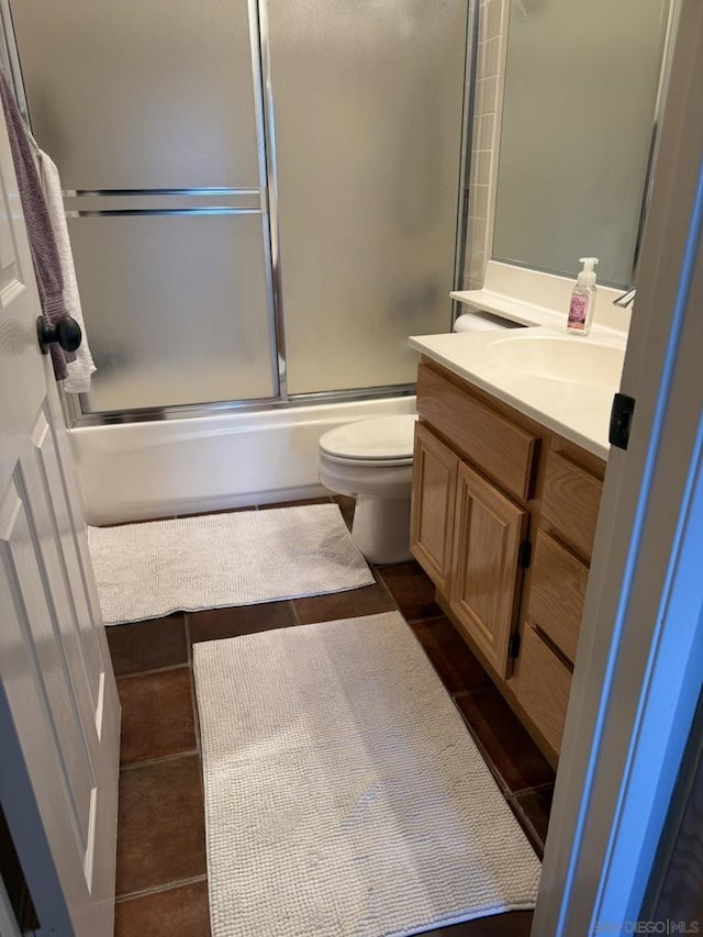 full bathroom with bath / shower combo with glass door, toilet, and vanity