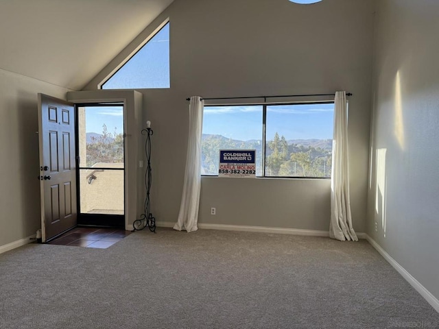 entrance foyer with high vaulted ceiling, a mountain view, and dark carpet