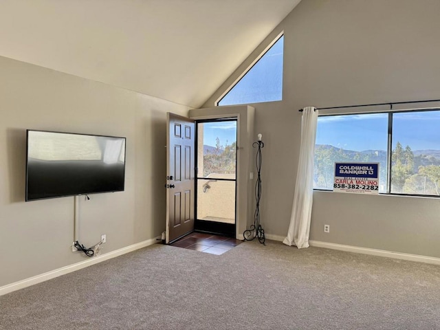 unfurnished living room featuring vaulted ceiling, a mountain view, and dark carpet