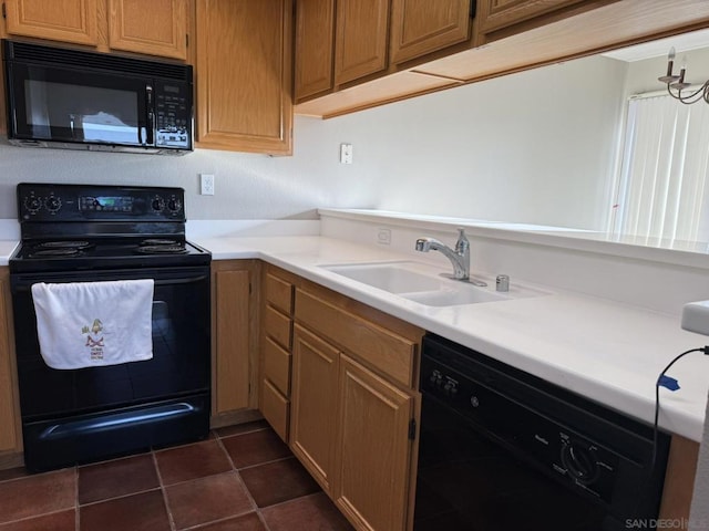 kitchen with sink, dark tile patterned floors, and black appliances