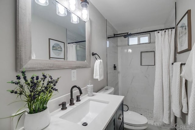 bathroom featuring toilet, vanity, and curtained shower