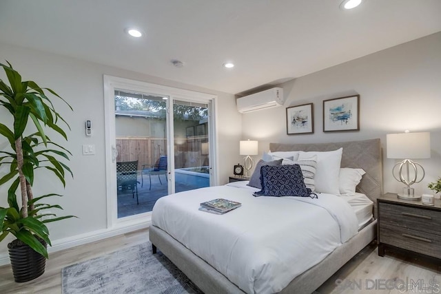 bedroom with light hardwood / wood-style flooring, access to outside, and a wall mounted air conditioner