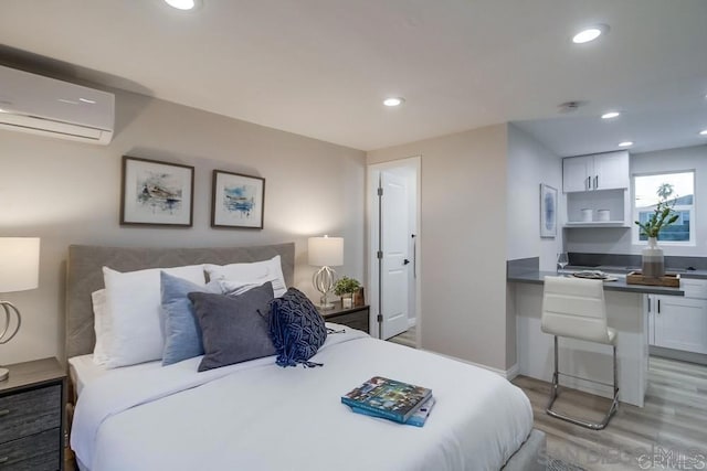 bedroom with hardwood / wood-style flooring and a wall unit AC