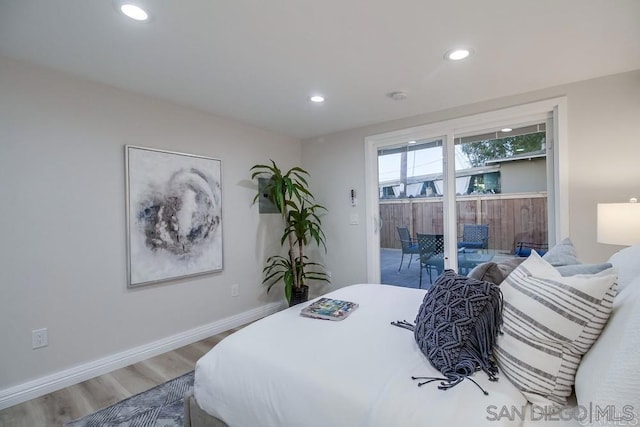 bedroom with wood-type flooring and access to outside