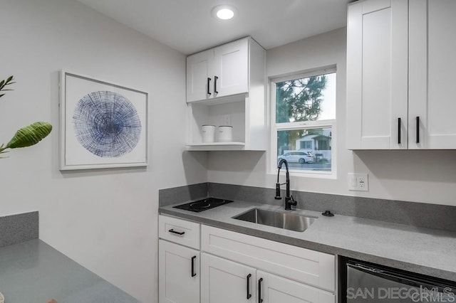 kitchen featuring stainless steel dishwasher, white cabinets, and sink