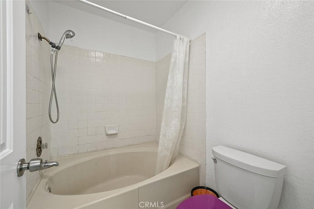 bathroom featuring toilet and shower / bath combination with curtain