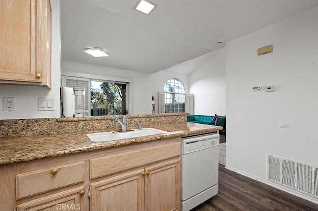 kitchen featuring dishwasher, light brown cabinets, light stone counters, and sink